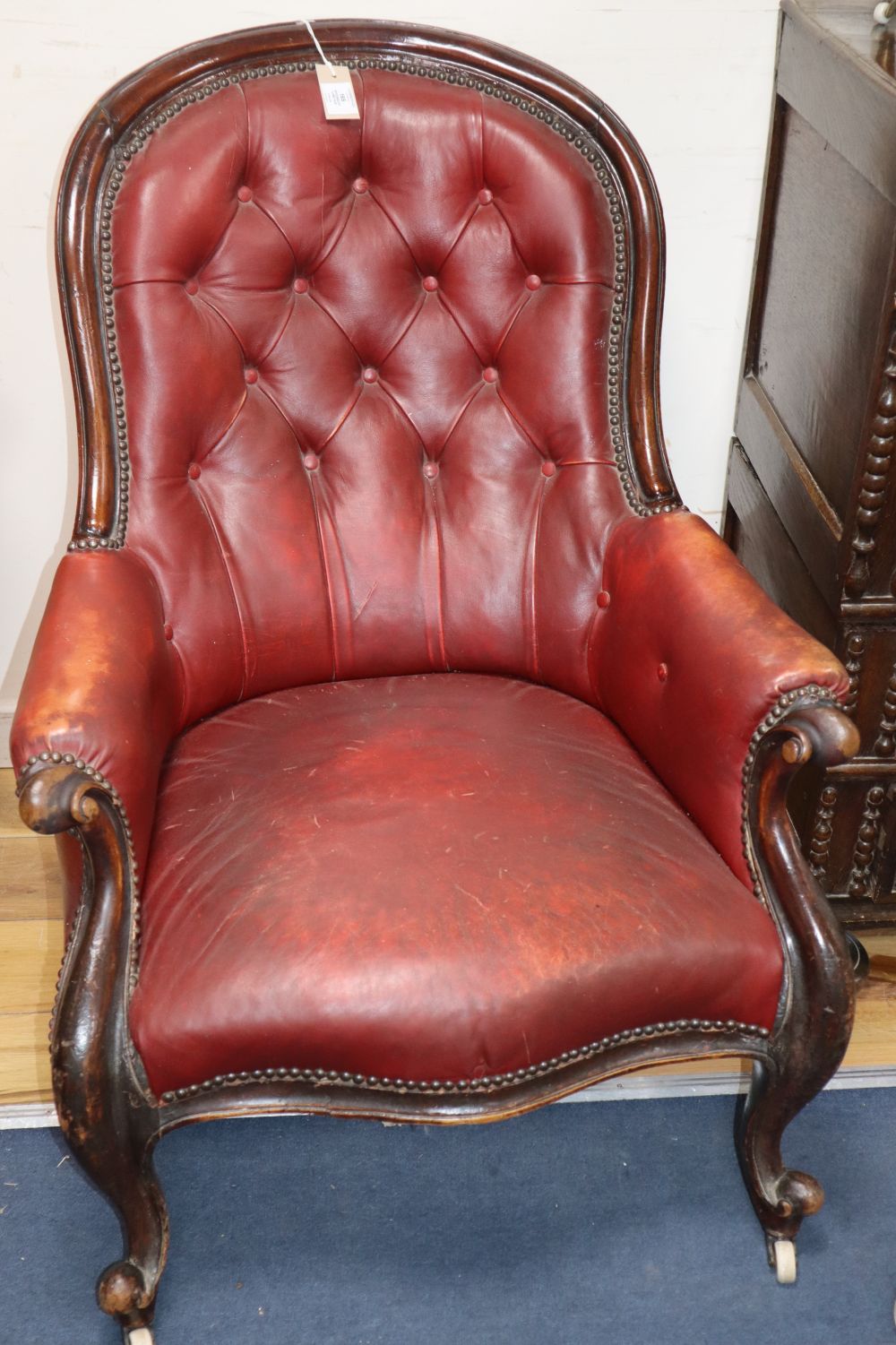 A Victorian red buttoned leather upholstered spoonback armchair